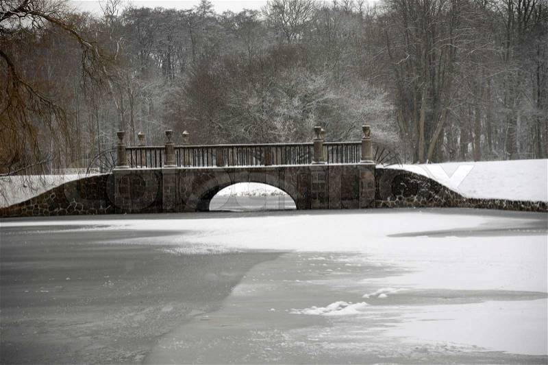 Bridge over frozen lake at winter time, stock photo
