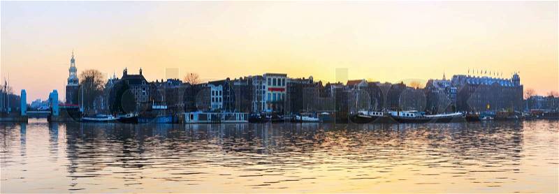 Panorama of Amsterdam old town with reflection in Amstel river, stock photo
