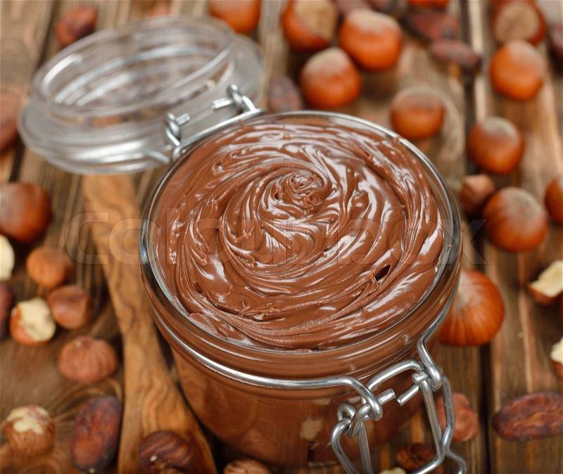 Chocolate paste in a glass jar on a brown background, stock photo