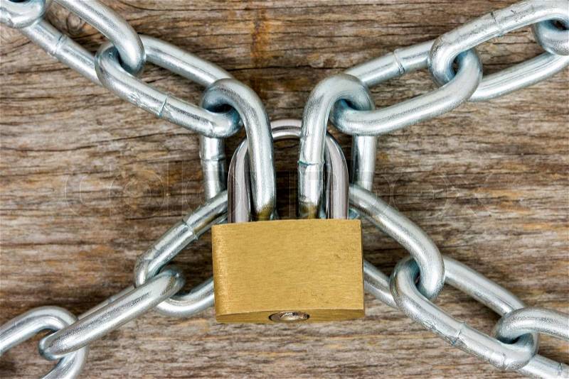 Steel chains and yellow padlock on the wooden background, stock photo
