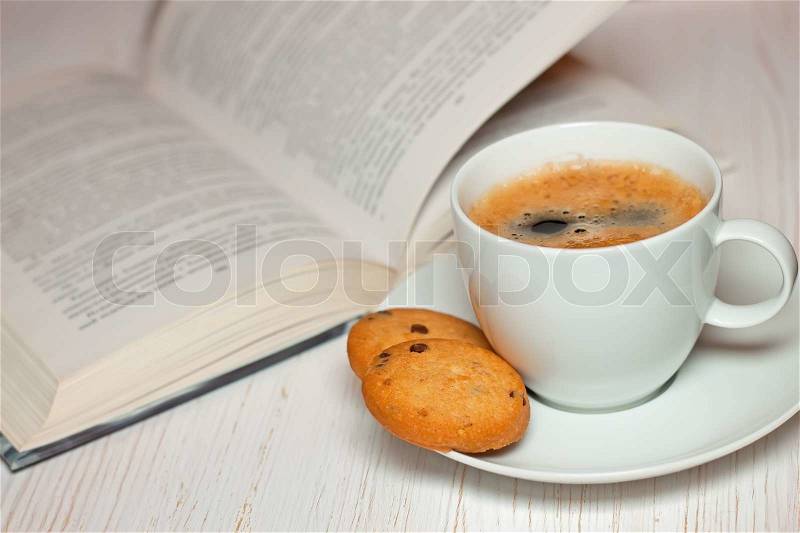 Book and coffee with cookies on a white wooden table, stock photo