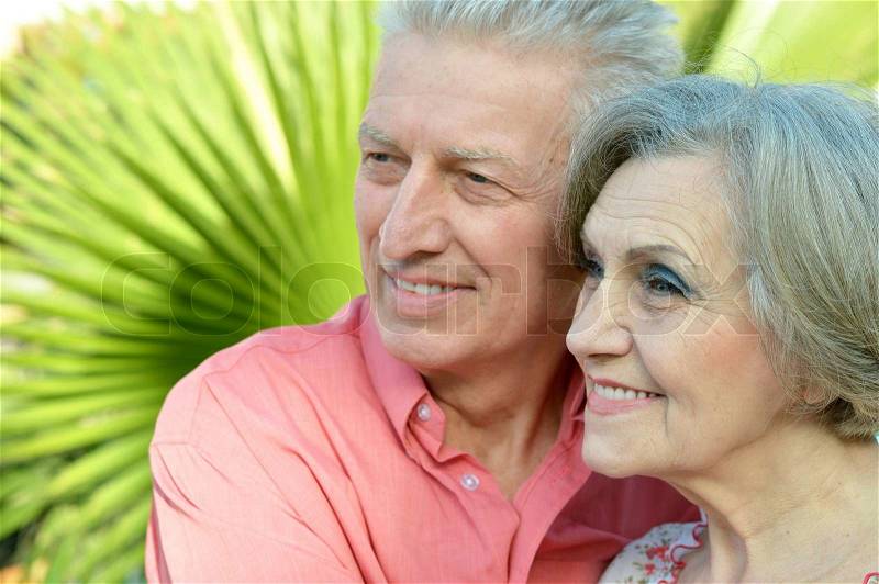Nice old people went to a resort on palm leaf backgroun, stock photo