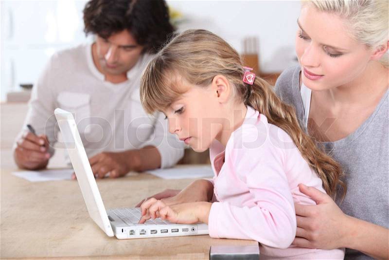 Parents with daughter on computer, stock photo