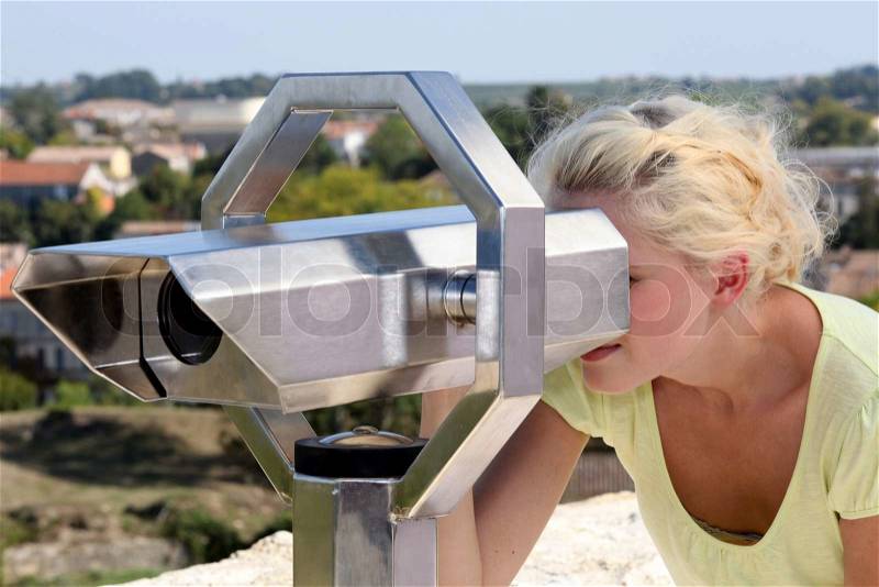 Woman looking through telescope, stock photo