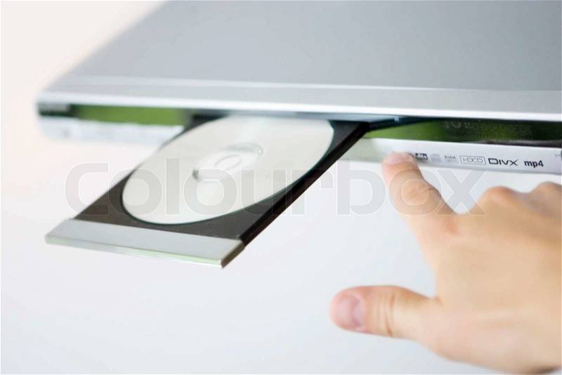 A hand pushing a button on a dvd player, stock photo