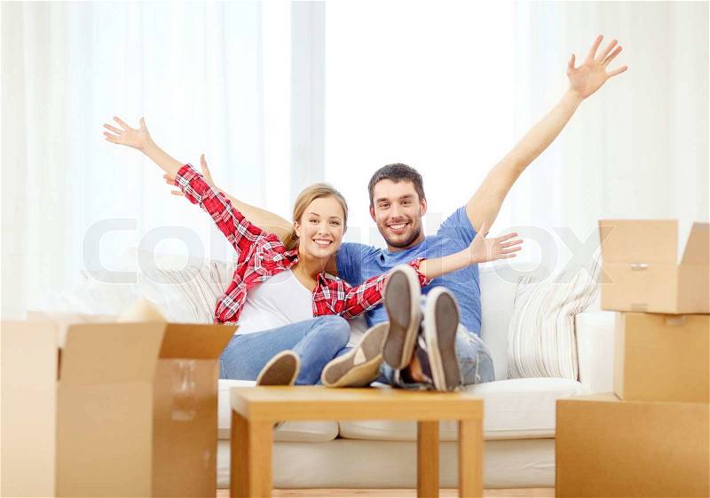 Moving, home and couple concept - smiling couple relaxing on sofa in new home, stock photo