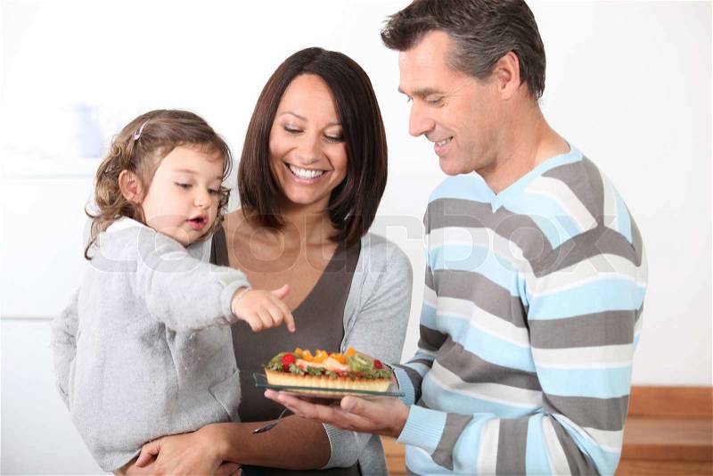 Parents preparing a bite to eat for little girl, stock photo