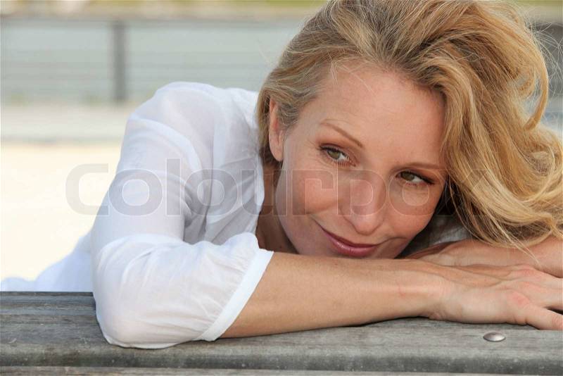 Woman leaning on a bench, stock photo