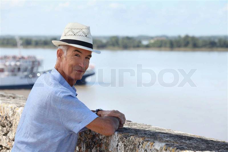 Man stood by a small port, stock photo