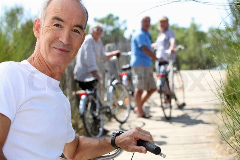 A senior man doing bike with friends in summer, stock photo
