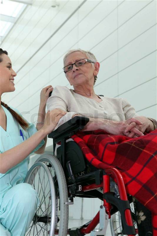 Nurse with elderly woman in wheelchair, stock photo