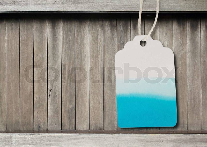 Blue watercolor label paper on brown wood background, stock photo
