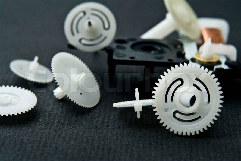 Cog-wheels from a clock on a black background, stock photo