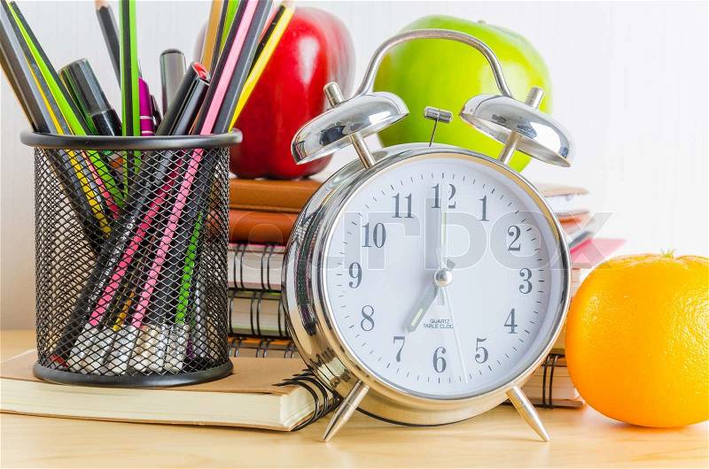 Back to school , note book , clock , pencil , apple on wood table, stock photo