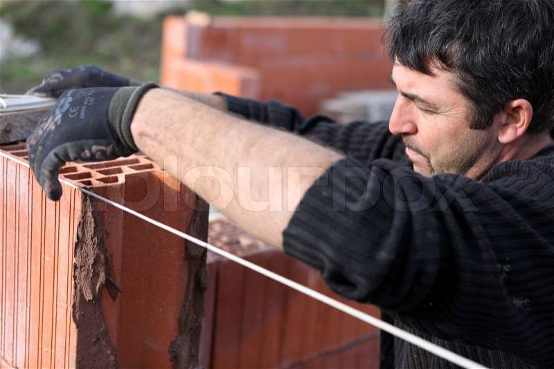 A bricklayer busy at work, stock photo