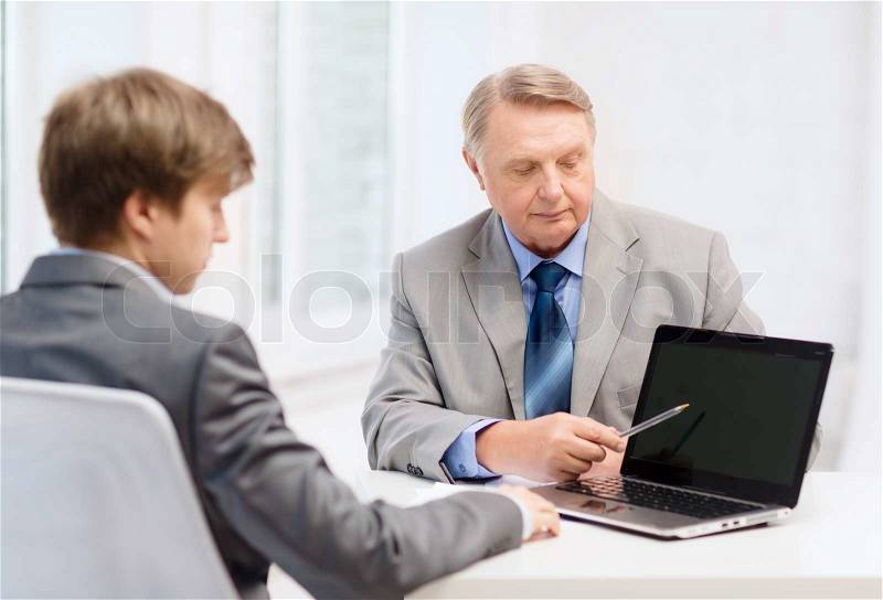 Business, advertisement, technology and office concept - older man and young man with laptop computer in office, stock photo
