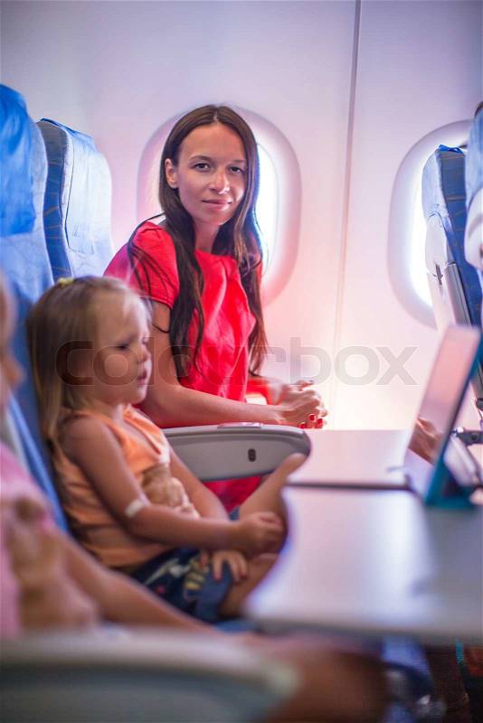 Young mother with her little daughters in the plane, stock photo