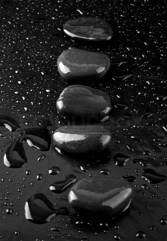 Stone in drops of water on a black background, stock photo