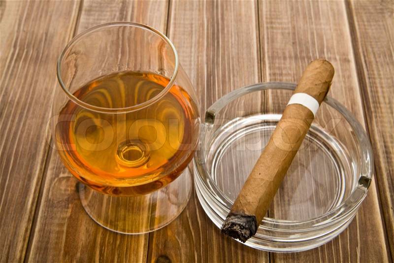 Glass and with a cigar on a wooden table, stock photo