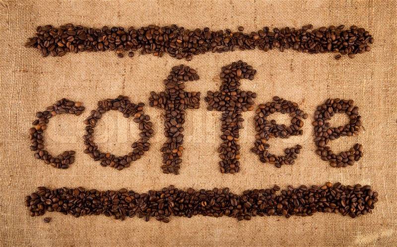 Inscription from grains of coffee on rough woven, stock photo