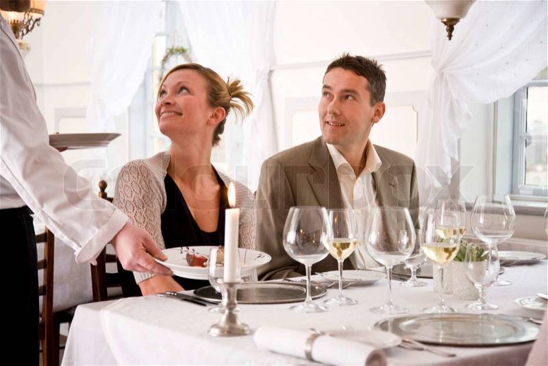 A waiter serving the restaurant guests with food, stock photo