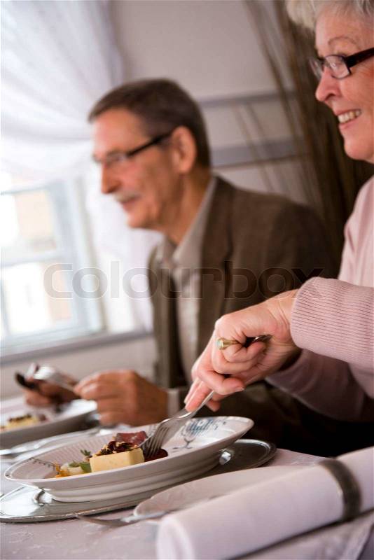 An elderly caucasian couple eating in a fancy restaurant, stock photo