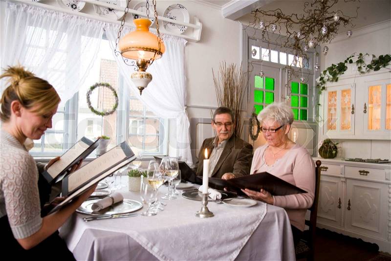 An elderly couple and their children in an elegant restaurant, stock photo