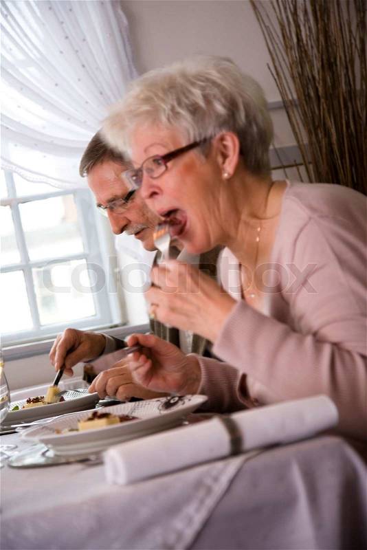 An elderly caucasian couple eating in a fancy restaurant, stock photo