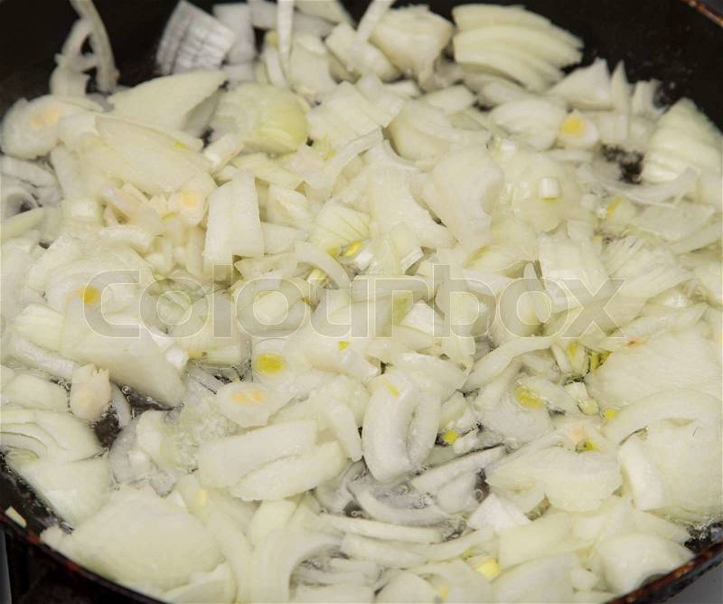 Fried onions in a pan, stock photo