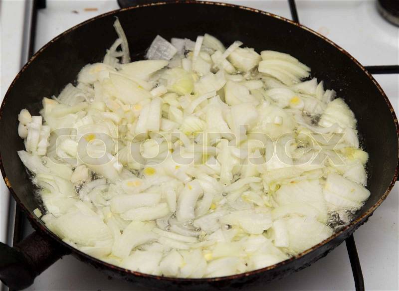 Fried onions in a pan, stock photo