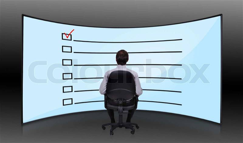 Businessman sitting in movie house and looking at plasma with checklist, stock photo
