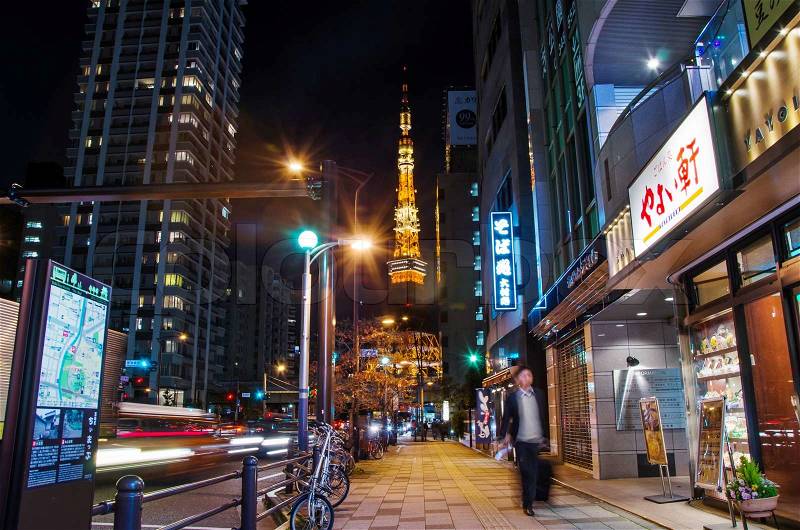 TOKYO, JAPAN - NOVEMBER 28: View of busy street at night with Tokyo Tower in the distance in Tokyo, Japan on November 28, 2013, stock photo