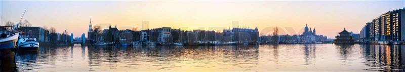 Panorama of Amsterdam old town with reflection in Amstel river, stock photo