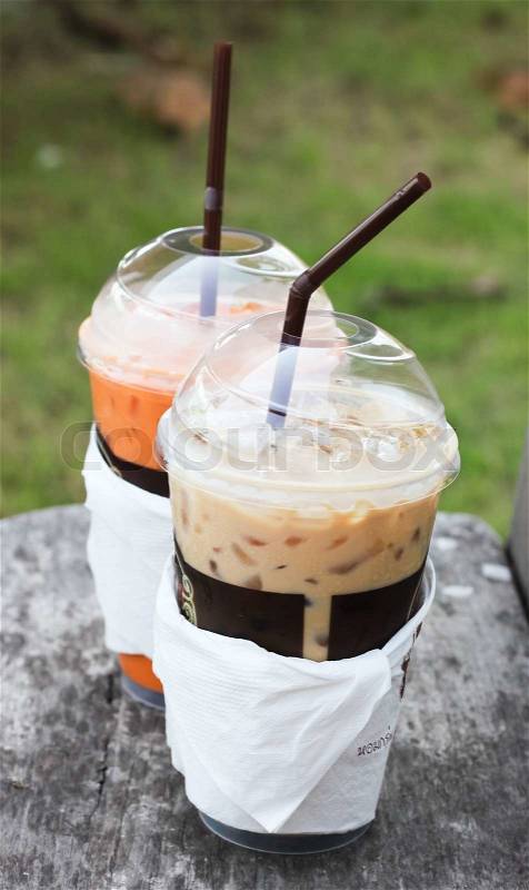 Iced coffee and milk tea in plastic cups wrapped with papers, stock photo