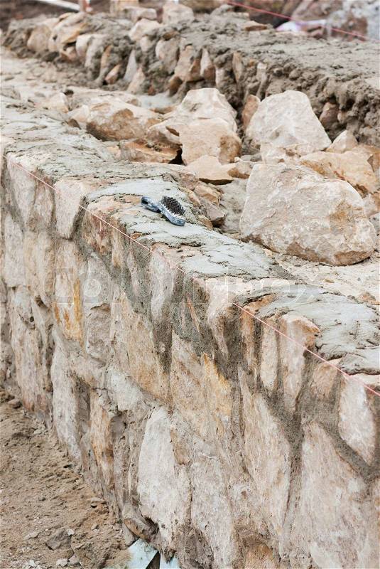 Step construction of a thick stone wall, stock photo