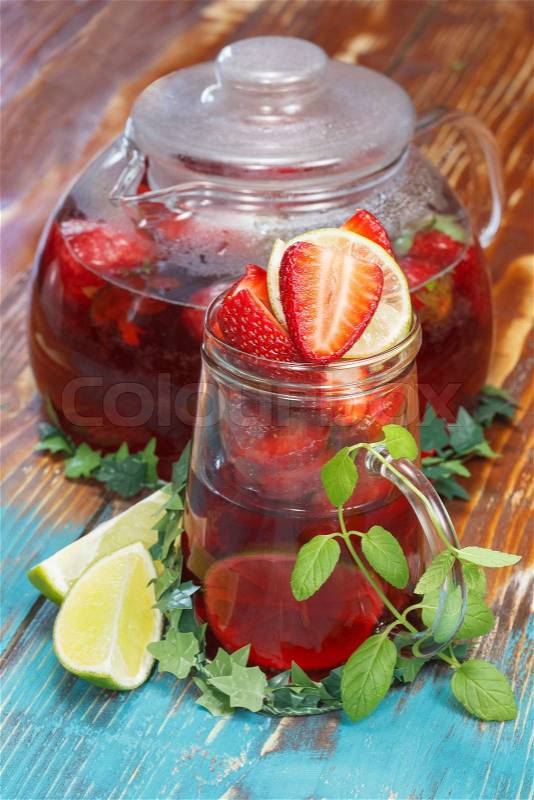 Strawberry tea. Strawberry tea in glass cup with teapot and fresh berries, stock photo