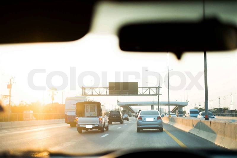 Vision of cars and road through driver's eyes with blur console as foreground, stock photo