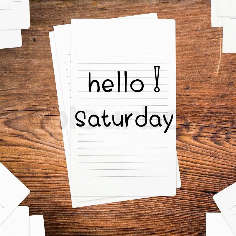 Hello Saturday on paper and wood table desk, stock photo