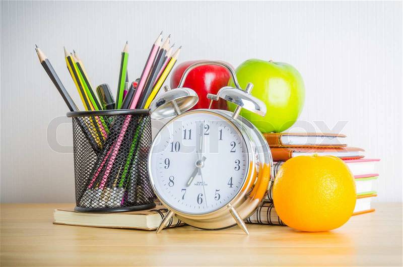 Back to school , note book , clock , pencil , apple on wood table, stock photo