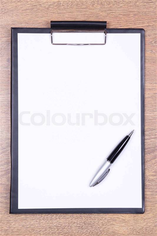 Clipboard with blank sheet of paper and pen on wooden table, stock photo