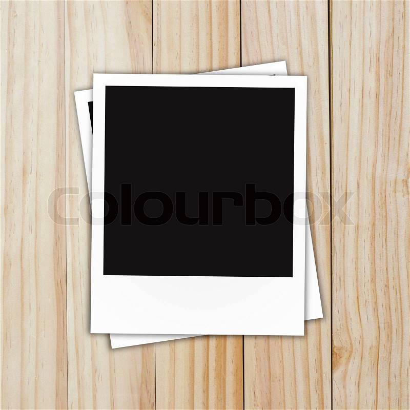 Blank polaroid photo frame on brown wood plank background, stock photo