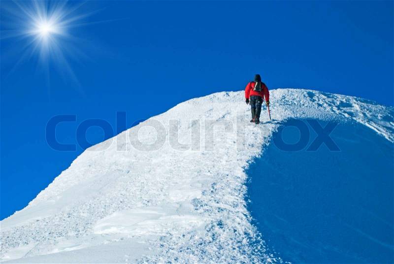 Lone male mountain climber on the summit, stock photo