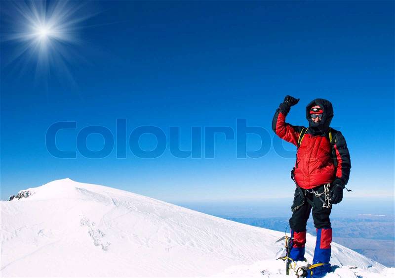 Lone male mountain climber on the summit, stock photo