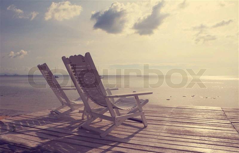 White wooden beach chair facing seascape,vintage filter effect, stock photo