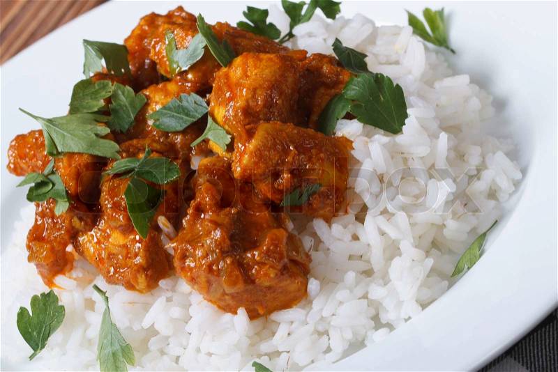 Chicken breast curry with rice on a white plate. Horizontal close-up , stock photo