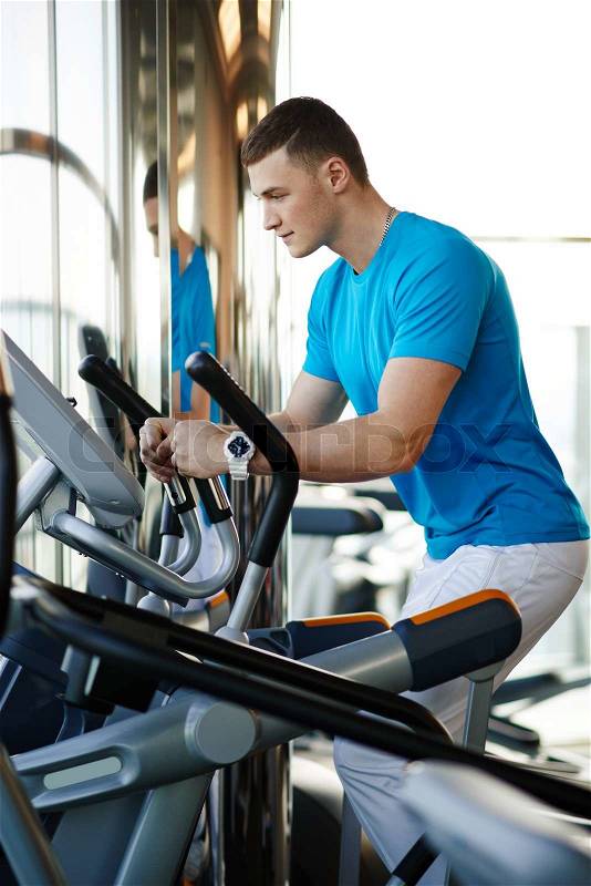 Athlete exercising on a stationary bike in the gym, stock photo