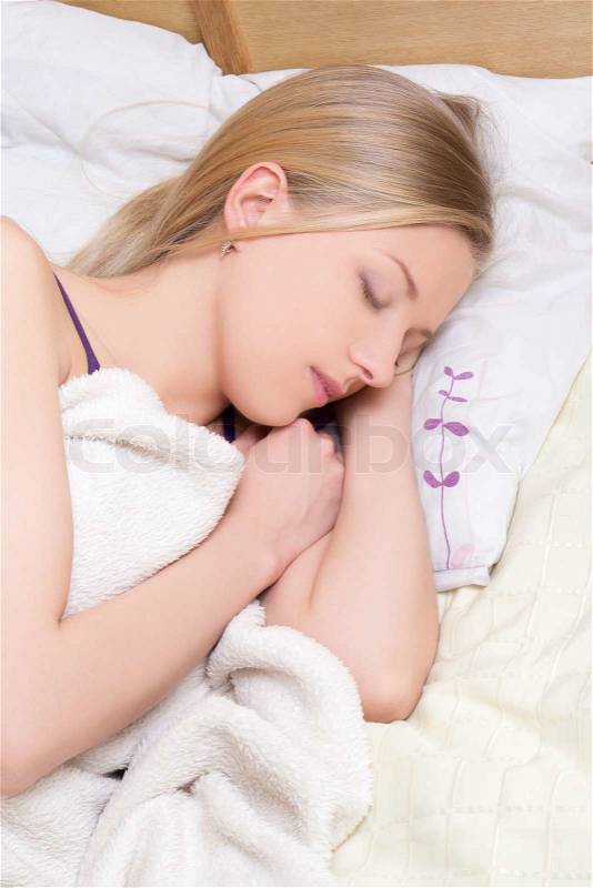 Young beautiful woman sleeps in bedroom at home, stock photo