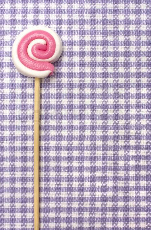 Spiral lolly pop candy on background in purple cellule, stock photo