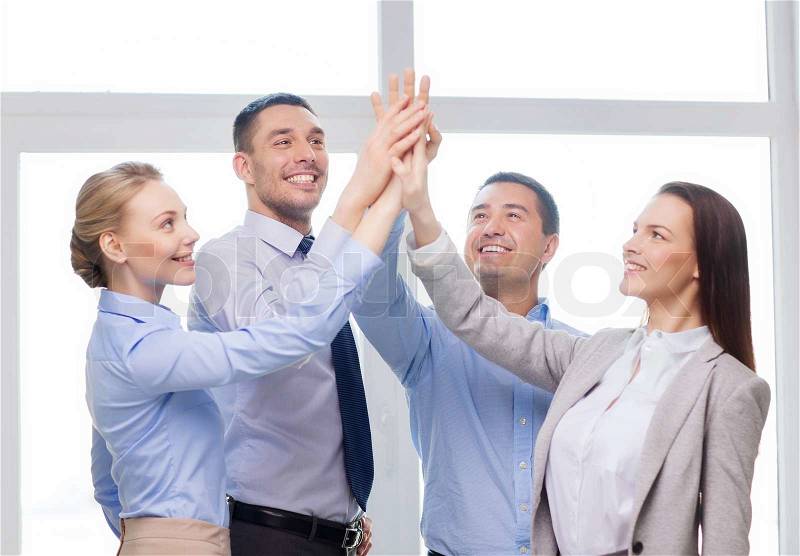Success, business, office and winning concept - happy business team giving high five in office, stock photo