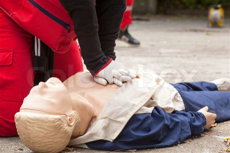 Paramedic demonstrates CPR on dummy, stock photo